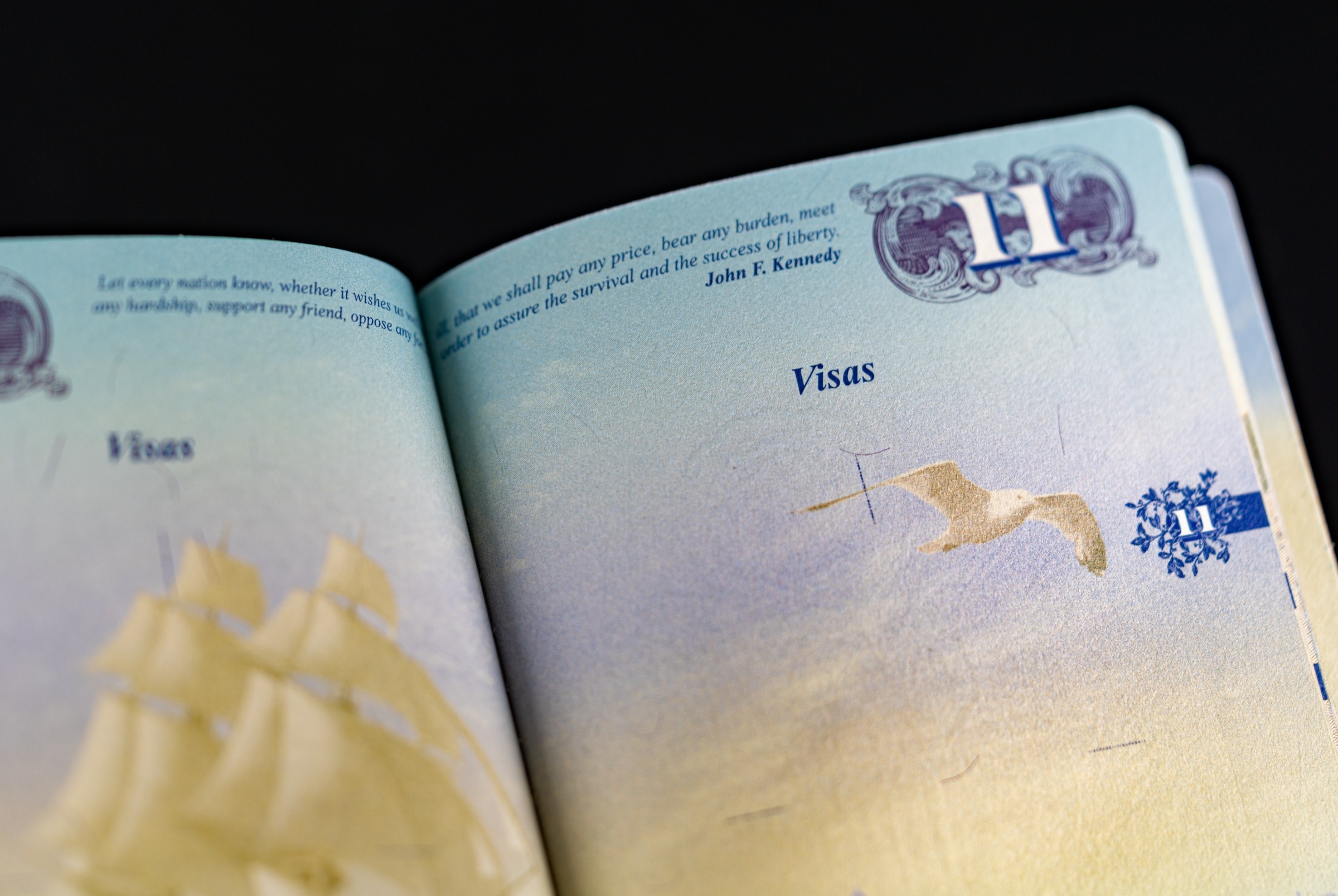 Open United States passport showing pages with visa stamps — symbolizing the USCIS adjudication pause on Iranian cases.