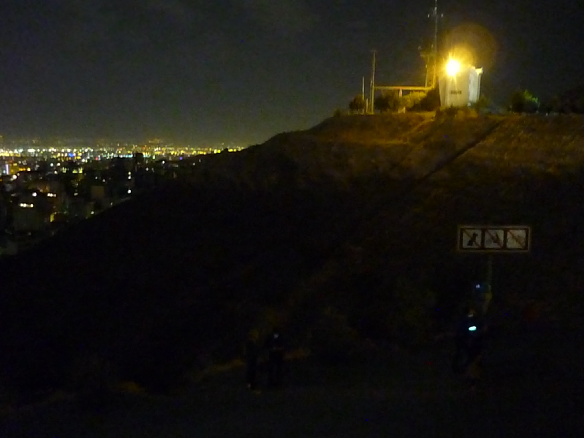 A dark walkway in Tehran with city lights still glowing in the background — a quiet reminder of life under nationwide internet blackout.